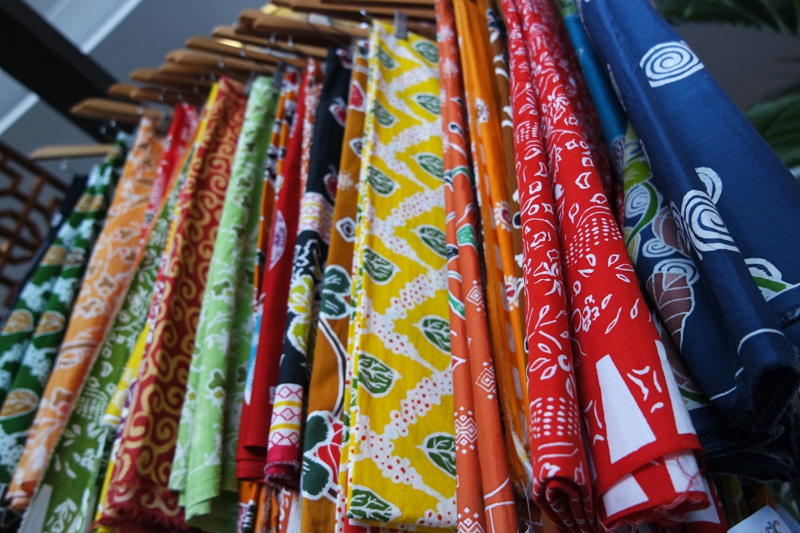 a bunch of different colored ties hanging on a rack